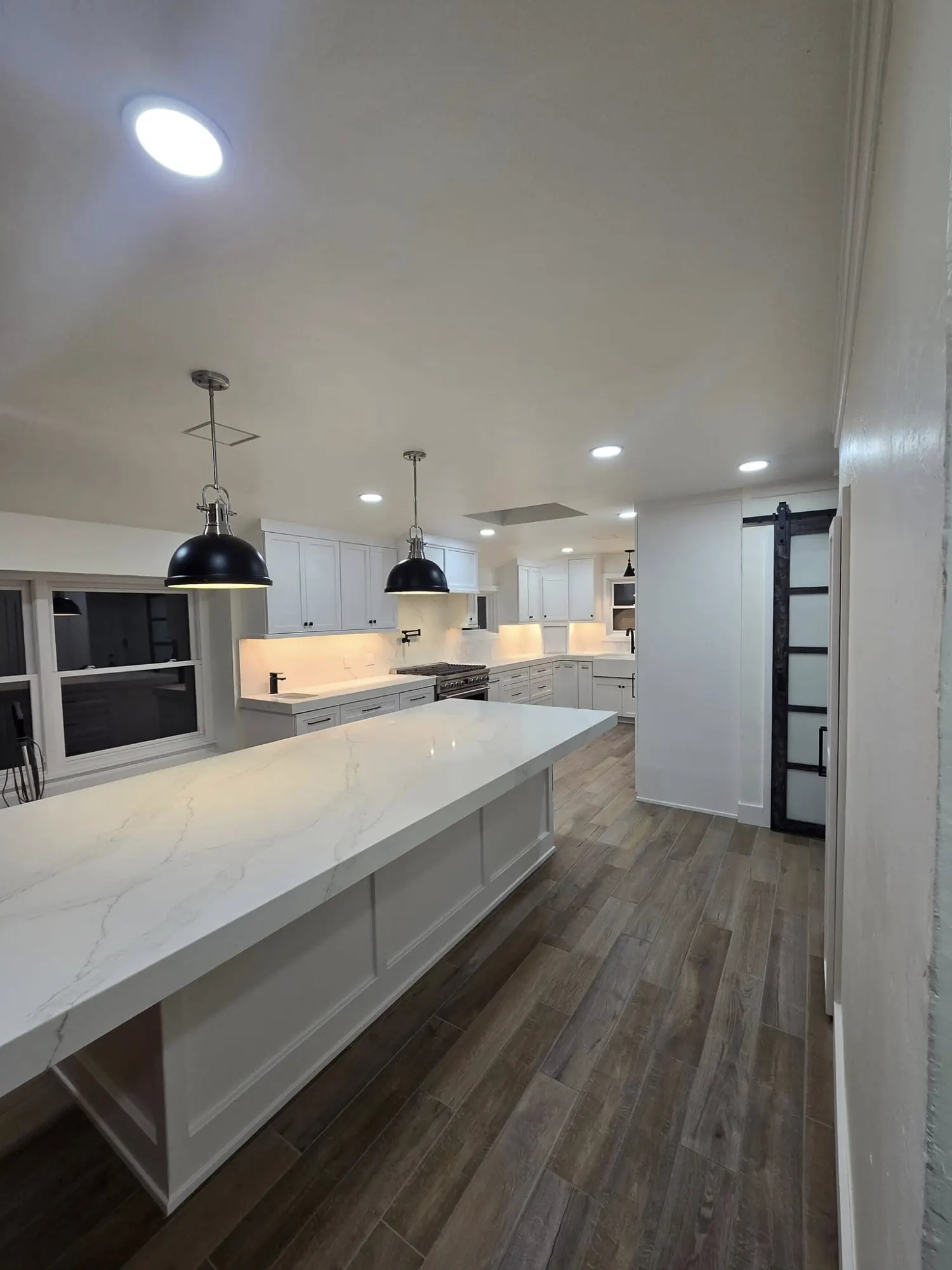 Bright remodeled kitchen and oversized island by Amni Renovations